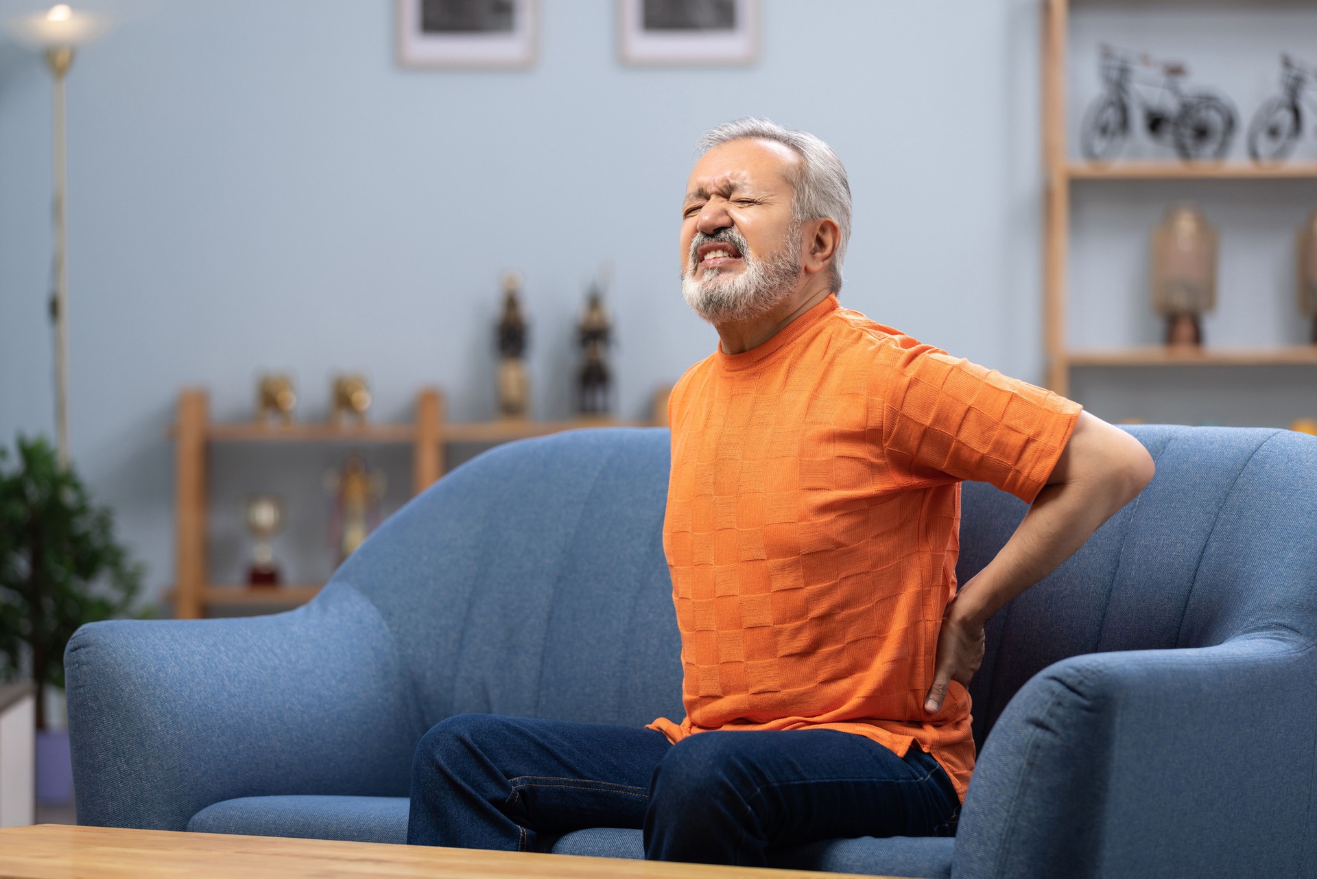 Senior man sitting on sofa at home stock photo